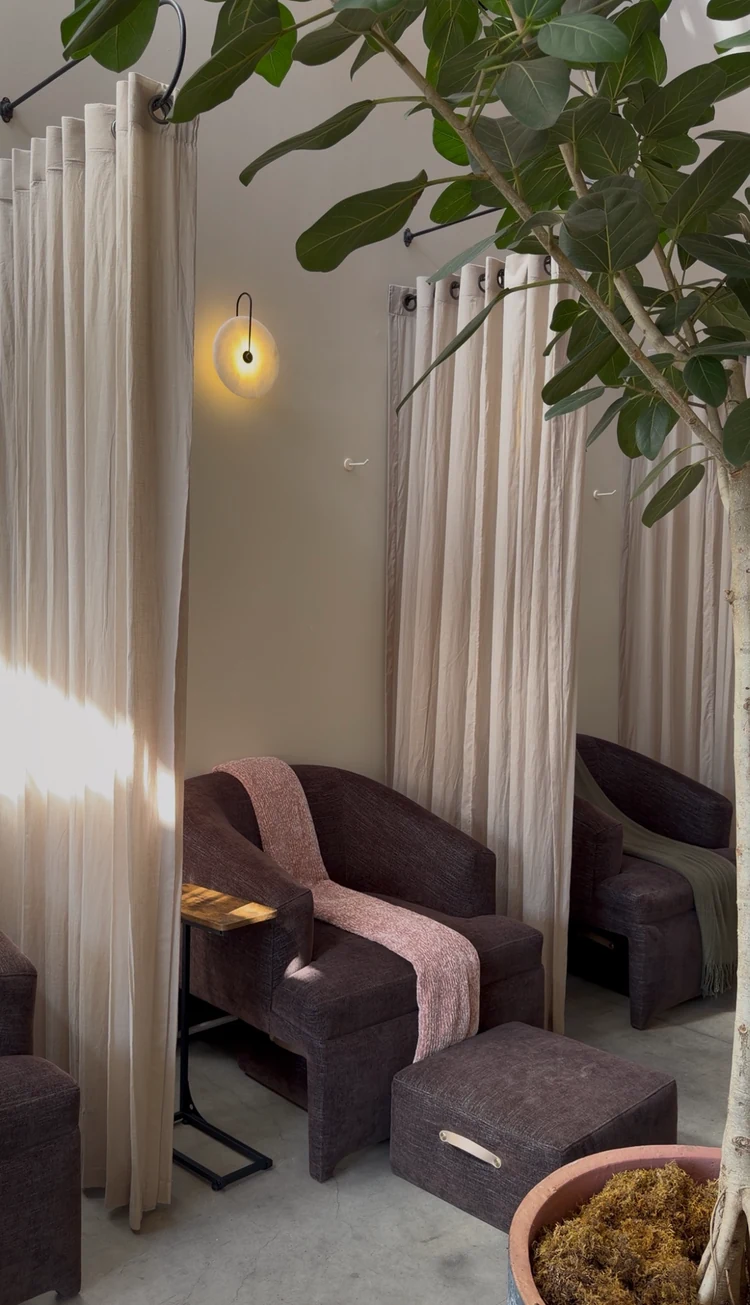 Linen curtains and a comfortable treatment lounge chair at Enforma